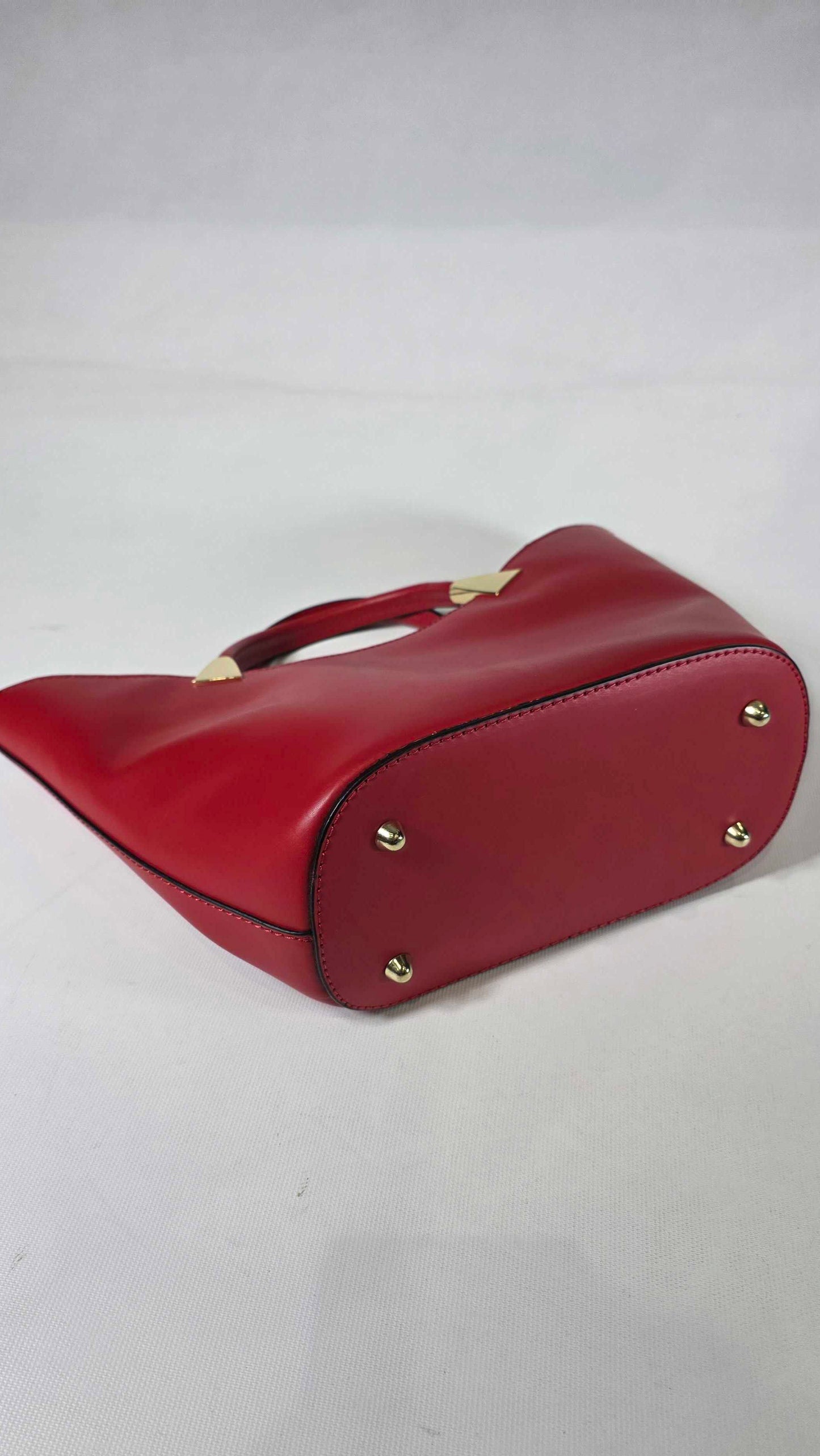 Red handbag with gold studs on a white background