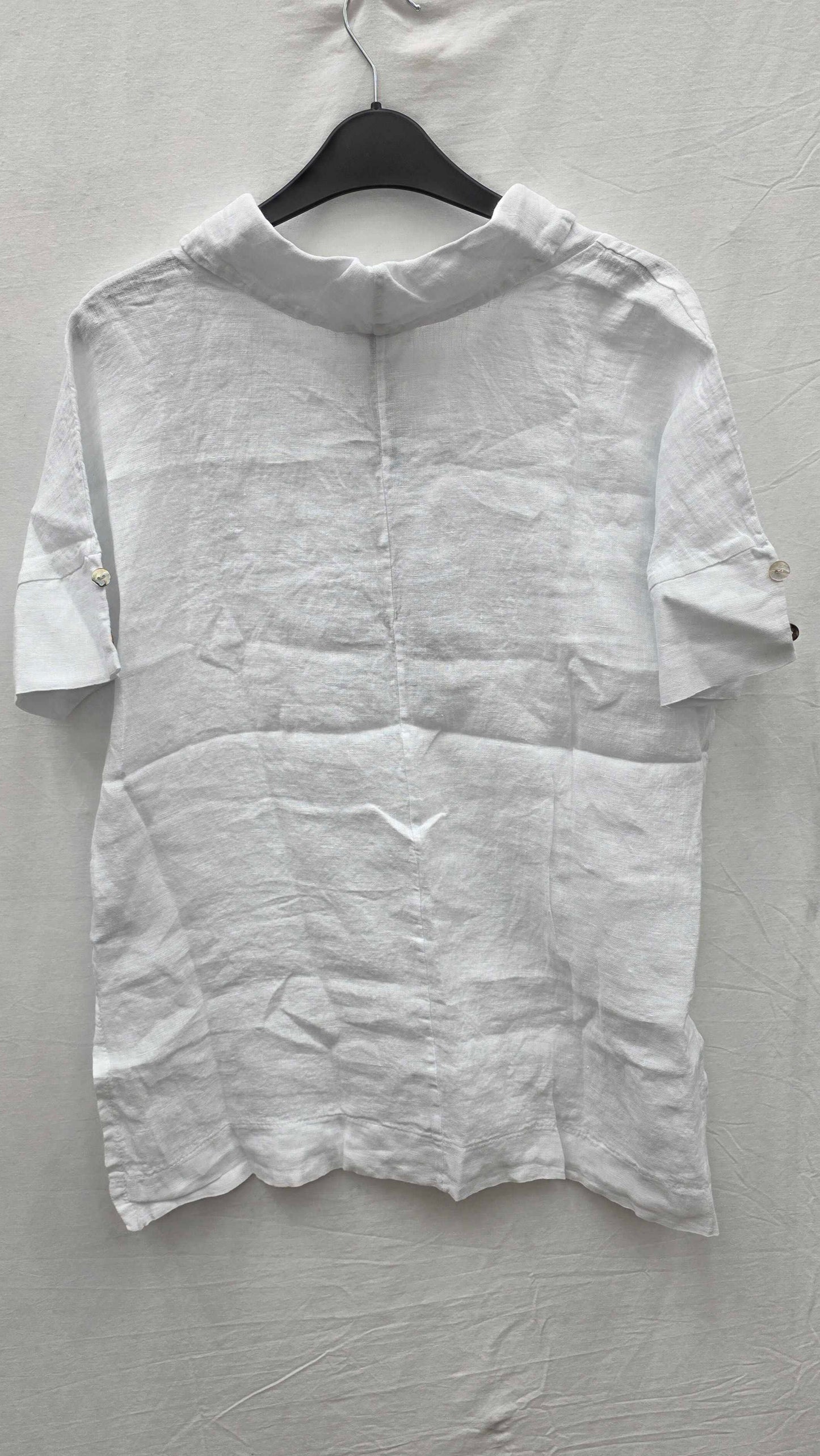 White shirt on a hanger against a gray background