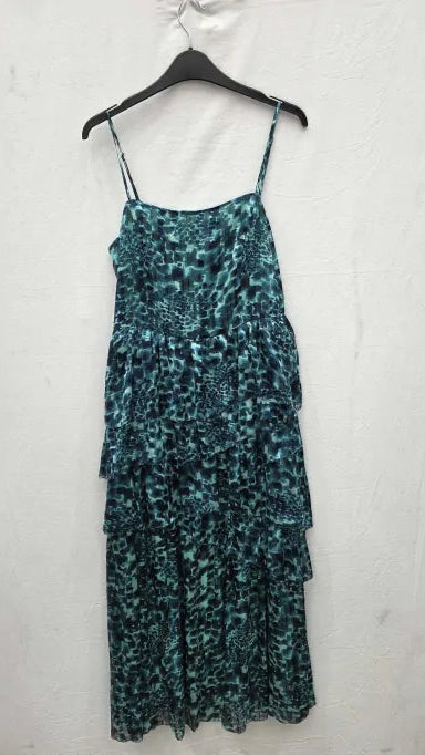 Green patterned dress on a hanger against a white background